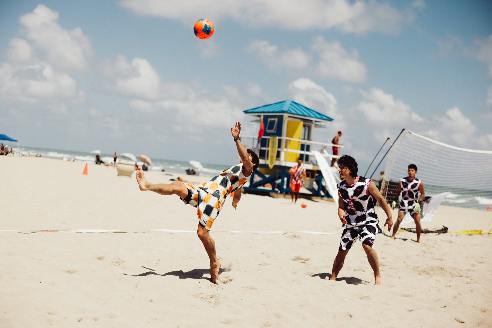 Player striking an overhead kick near the lifeguard tower